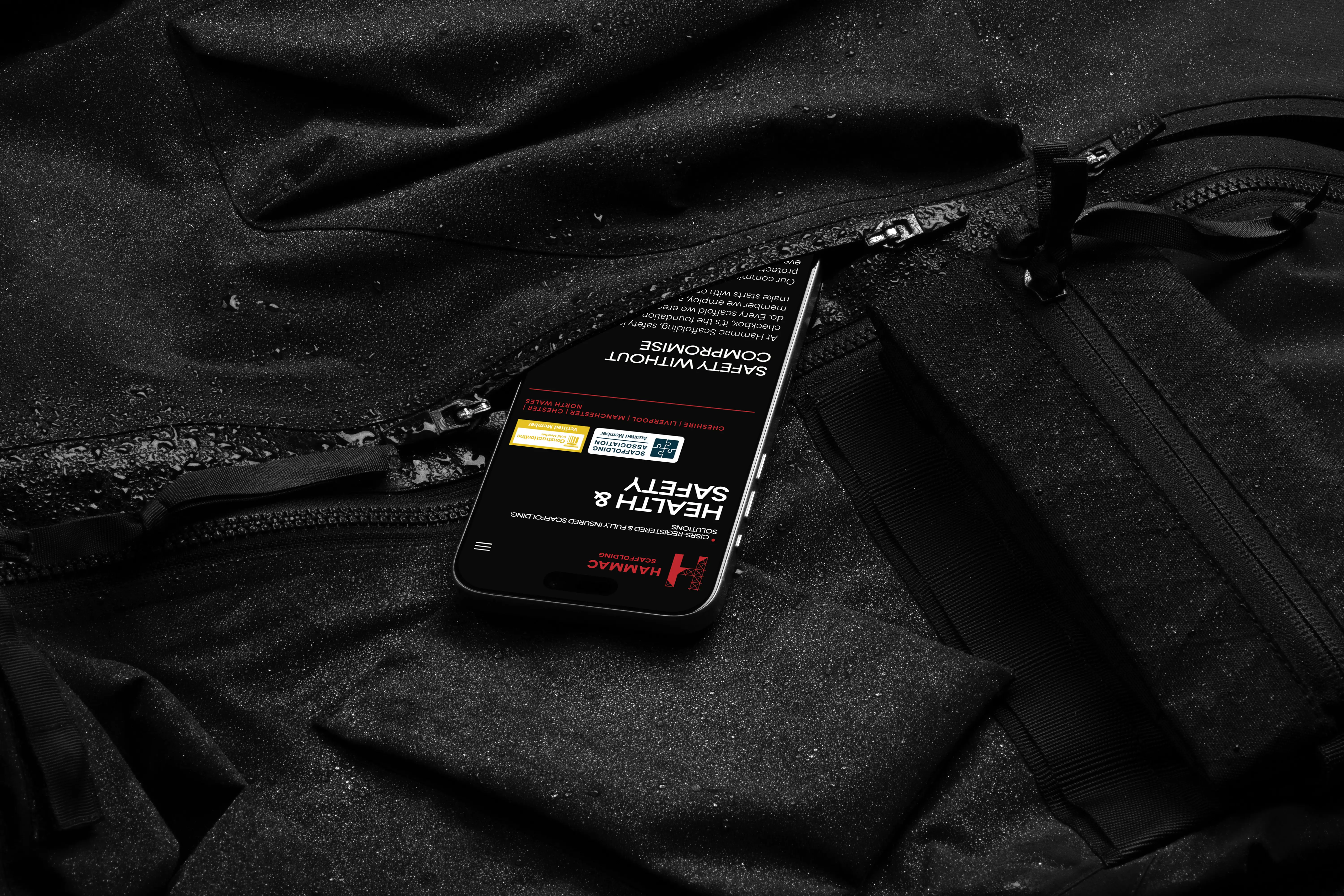 Hammac Scaffolding website on a phone in a jacket pocket