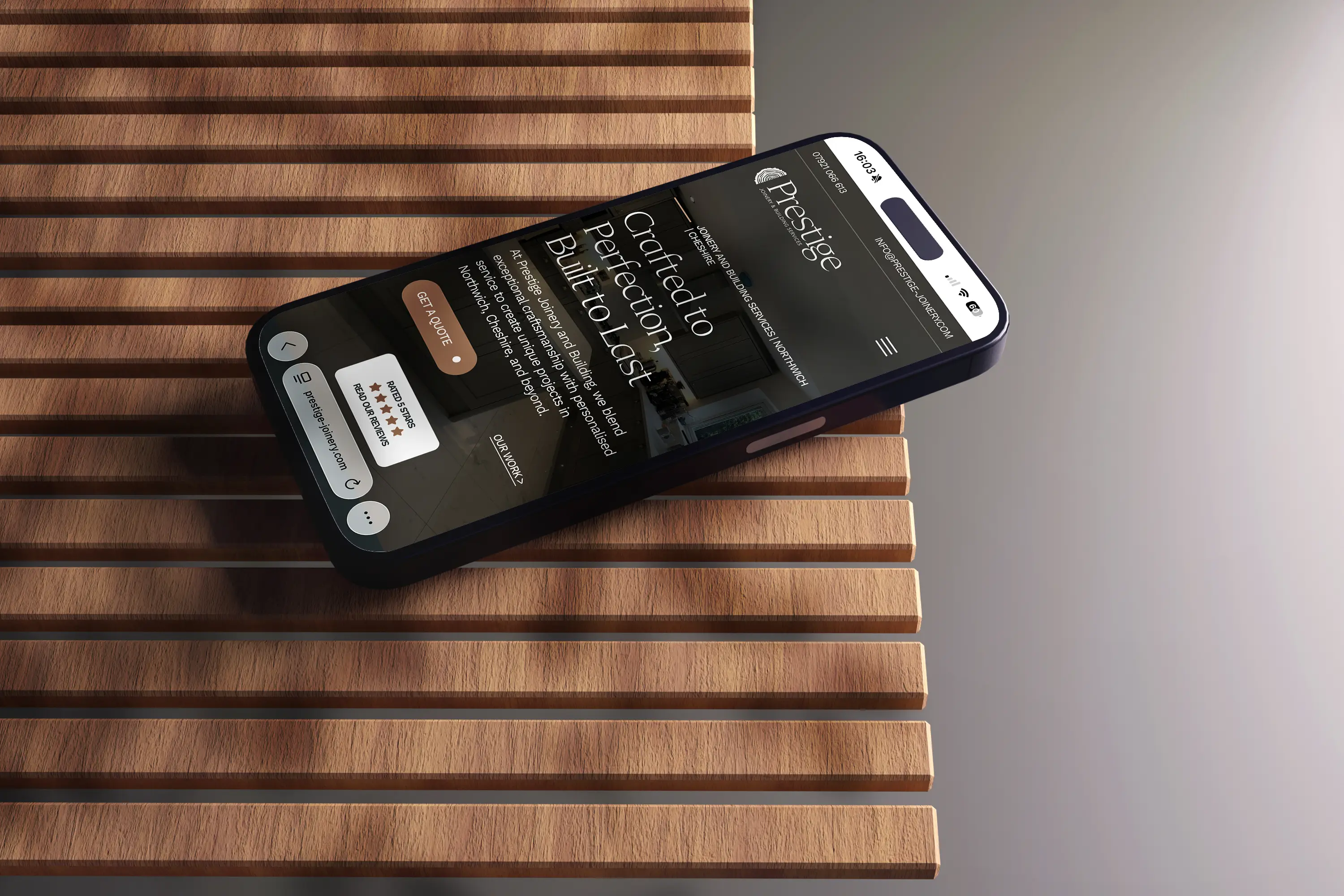 Prestige Joinery website on a phone resting on wooden slats